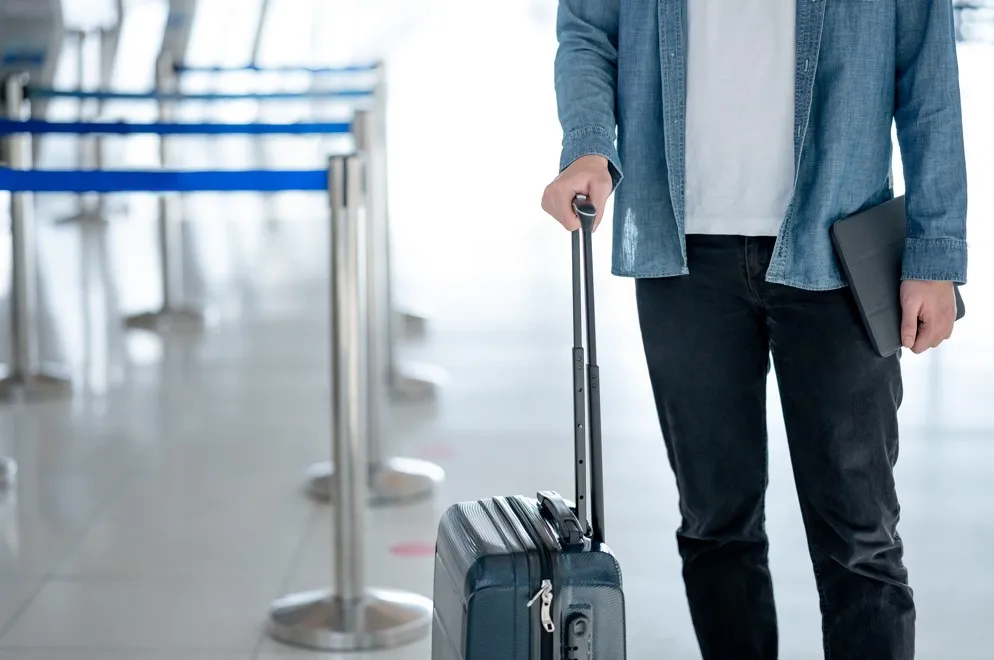 空港でスーツケースを持っている男性